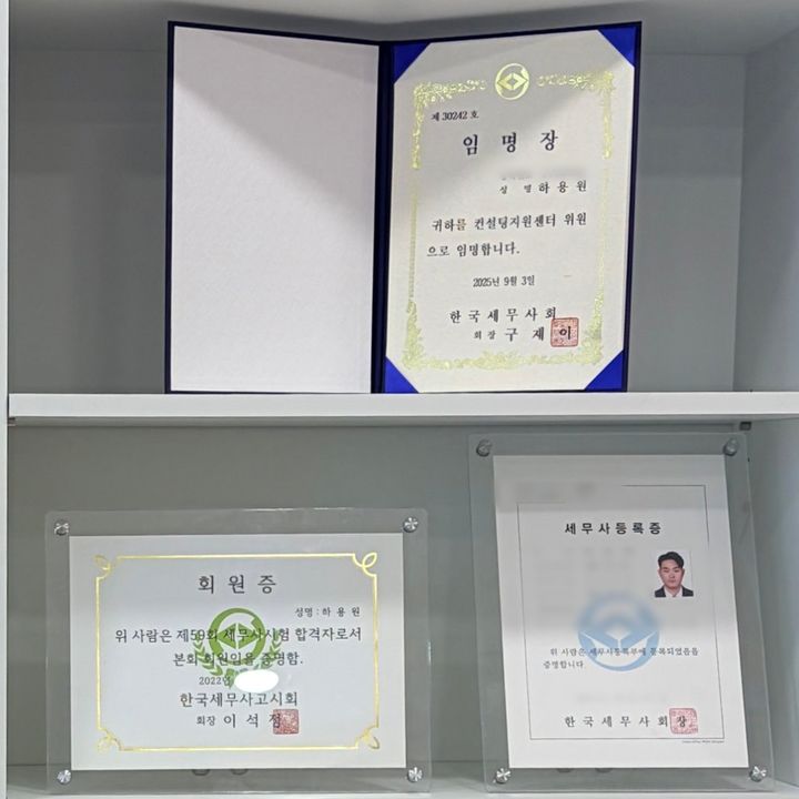 사무실 책장에 놓인 세무사 등록증과 한국세무사회 임명장